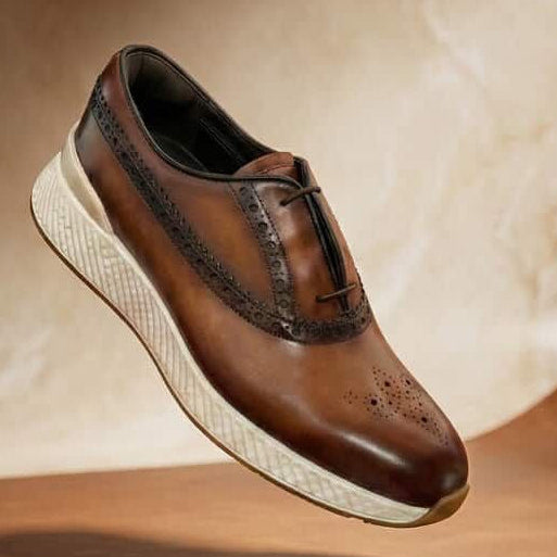Brown leather shoe with white sole on a wooden surface