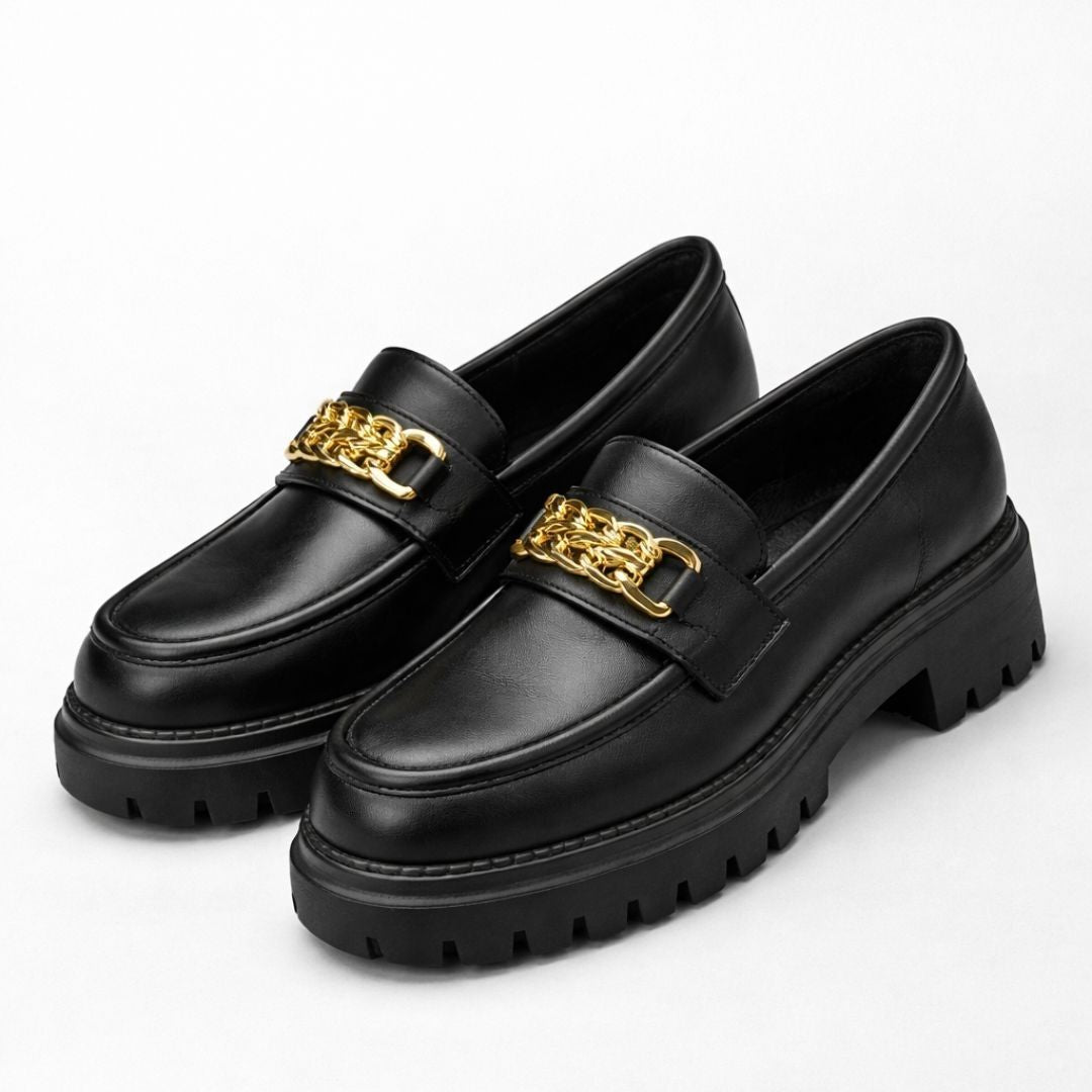 Black loafers with gold chain details on a white background