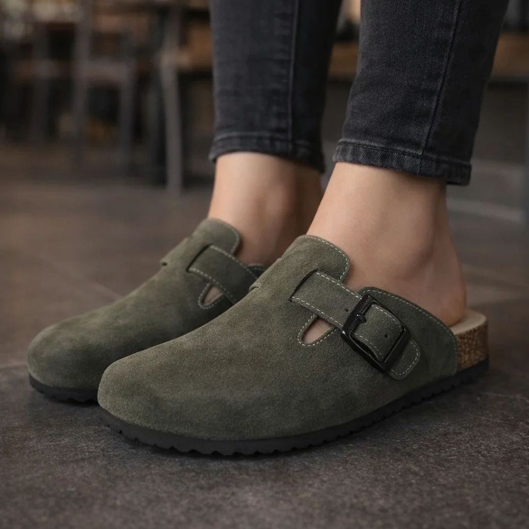 Green suede shoes with a buckle on a blurred background