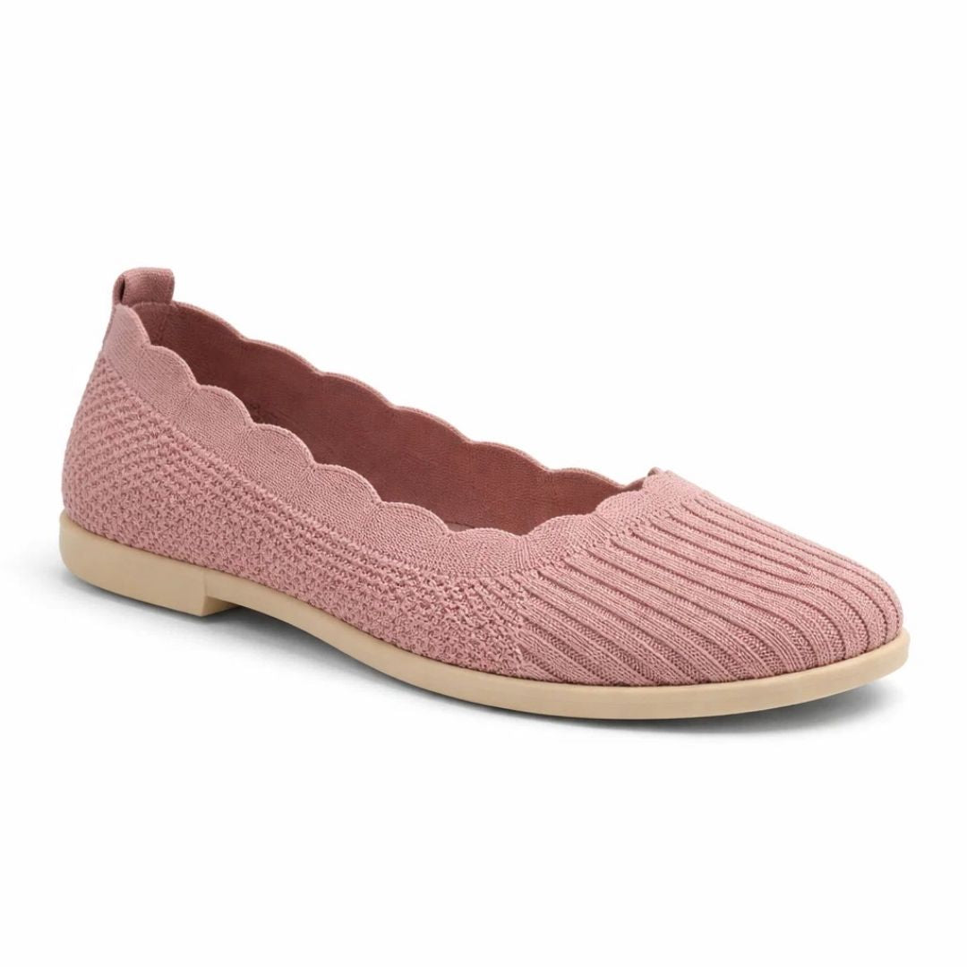 Pink flat shoe with scalloped edge on a white background