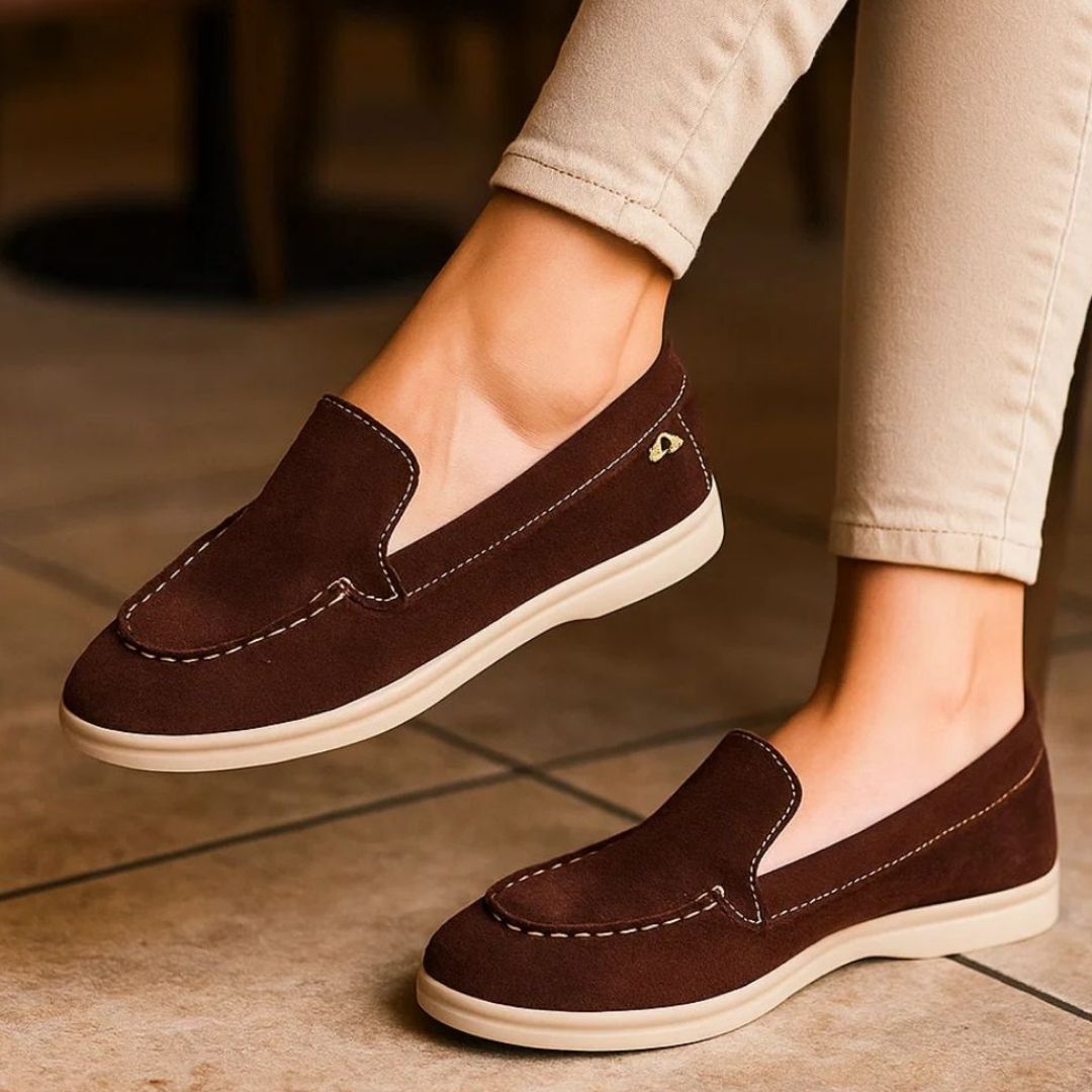 Brown loafers worn with beige pants on a tiled floor