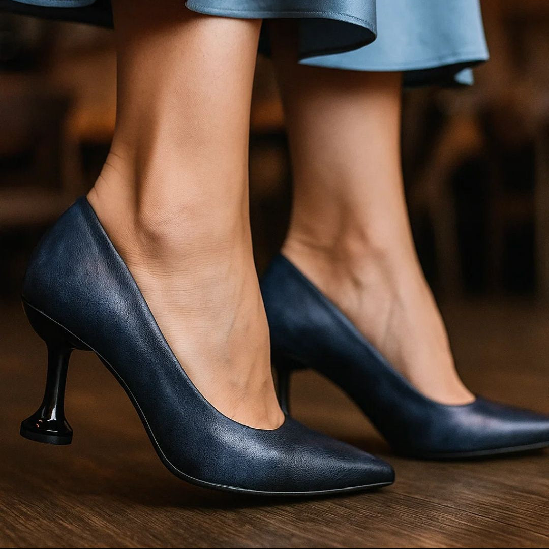Black high-heeled shoes worn with a light blue skirt on a blurred background