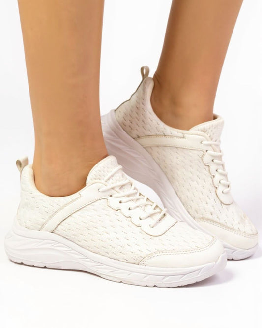 White sneakers worn on a white background