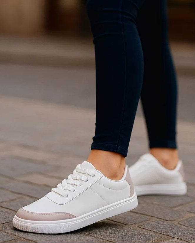 Person wearing navy leggings and white sneakers on a blurred street background