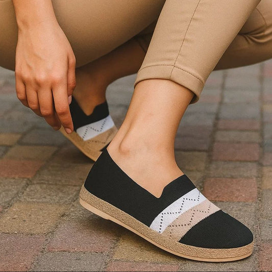Person wearing beige pants and black and white shoes on a paved surface