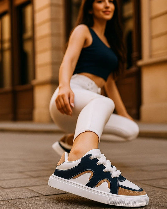 Person wearing navy and brown sneakers with white laces on a street.
