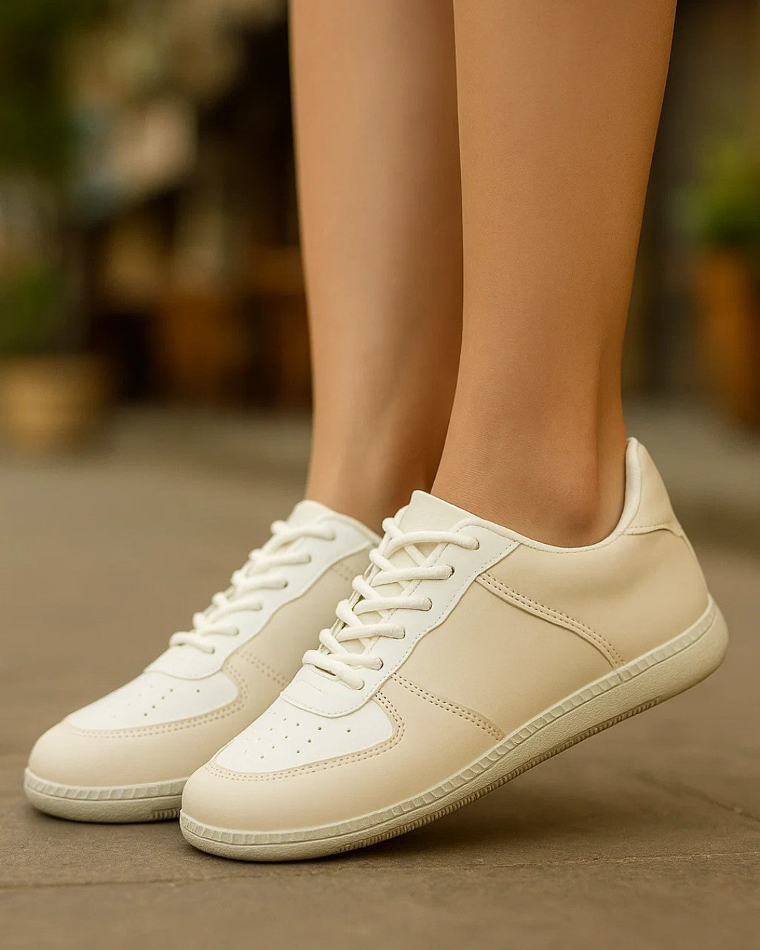 Beige sneakers worn by a person on a blurred background