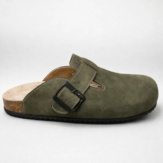 Green suede clog shoe with a black buckle on a white background